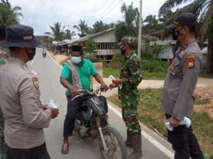 Babinsa Koramil 09/Langgam Bersama Polsek Langgam Bagikan Masker dan Sosialisasi PPKM