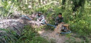 Anggota Satgas TMMD Ke-110 Kodim 0313/ KPR Bersama Warga Kuras Air yang Membanjiri Jalan