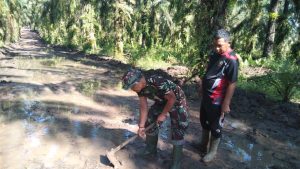Satgas TMMD Ke-110 Kodim 0313/ KPR Berjibaku Alirkan Genangan Air di Jalan Baru