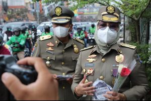 Peringati HUT Ke-71, Satpol PP Kota Depok Turun ke Jalan Berbagi Bunga dan Masker