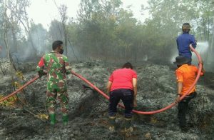 Babinsa dan Bhabinkamtibmas Bersinergi Lakukan Pemadaman Kebakaran Lahan