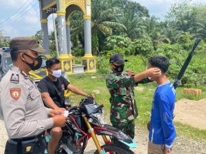 Lindungi Warga Dari Covid-19, Babinsa Koramil 14/Kepenuhan Bagikan Masker Gratis