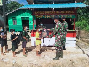 Personel Satgas Yonif 144/JY berikan Bantuan Tas Sekolah