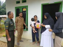 Sebagai Upaya Penurunan Stunting, Babinsa Koramil 16/Tapung Dampingi Bidan Desa Salurkan Susu Gratis