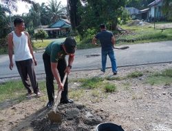 Babinsa Bersama Warga Gotong -Royong Timbun Jalan Berlubang