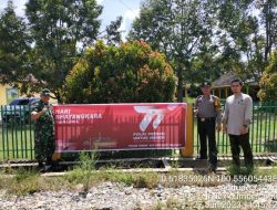 Hut Bhayangkara Ke-77, Bhabinkamtibmas Polsek Tandun Bersama Babinsa dan Warga Desa Pasang Spanduk