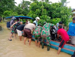 Menggunakan Perahu,Danramil 13/Rkn Bersama Anggota Bantu Masyarakat Ingin Menyeberang Saat Banjir