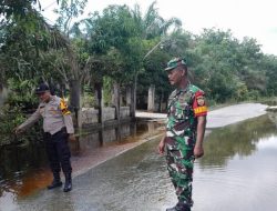 Wujud Perhatian, Babinsa Bersama Bhabinkamtibmas Pantau Lokasi Banjir di Wilayah Binaannya