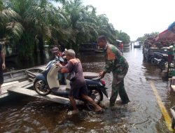 Berikan Rasa Aman, Babinsa Bantu Warga Menaikan Motor Keatas Perahu