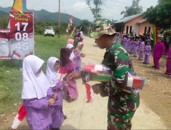 Tanamkan Cinta Tanah Air, Satgas TMMD Bagikan Bendera Merah Putih dan Snack Untuk Anak- Anak Sekolah