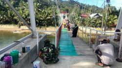 Finishing Lantai Jembatan, Satgas Kodim 0313/KPR Lakukan Pengecatan Papan Lantai Jembatan Gajah Bertalut