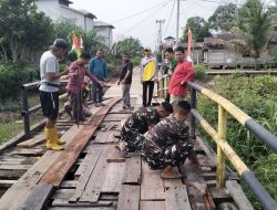 Perkuat Kemanunggalan TNI dan Rakyat, Satgas TMMD Ke-129 Kodim 0313/KPR dan Warga Gotong -Royong Perbaiki Jembatan jalan Desa